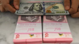 Pegawai menunjukkan uang rupiah dan dolar AS di Bank Syariah Indonesia, Tangerang Selatan, Banten, Rabu (21/1/2026). Nilai tukar rupiah pada penutupan perdagangan Rabu (21/1) bergerak menguat 20 poin atau 0,12 persen menjadi Rp16.936 per dolar AS dari hari sebelumnya Rp16.956 per dolar AS. ANTARA FOTO/Hafidz Mubarak A/wsj.