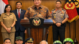 Airlangga Hartarto, Menko Perekonomian, memimpin konferensi pers pengumuman pencairan THR dan BHR Idulfitri 2026. THR diberikan kepada ASN, TNI, Polri, pensiunan, dan pekerja ojek online. Suasana terlihat ceria, dengan sejumlah penerima memegang amplop berisi THR.

Sumber Foto: Hasil ilustrasi berbasis informasi publik, tidak diambil dari sumber resmi.